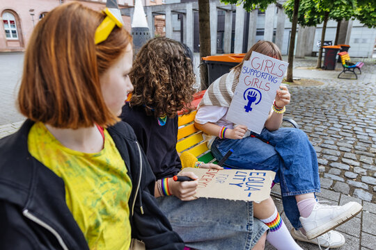 Friends making posters for LGBTQ equality and feminism outdoors