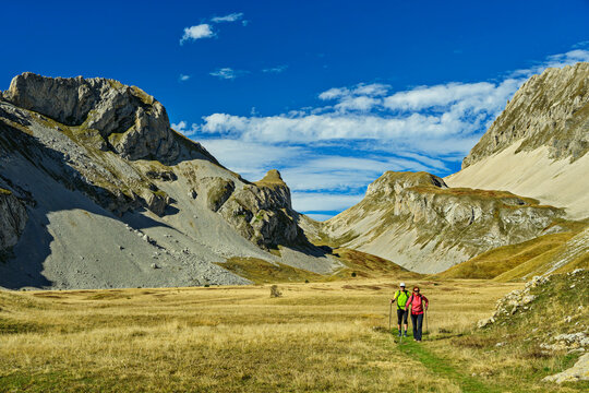 Man and woman hiking in Devoluy mountain valley