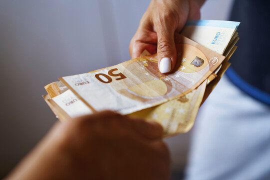 Hands exchanging Euro banknotes in a business transaction
