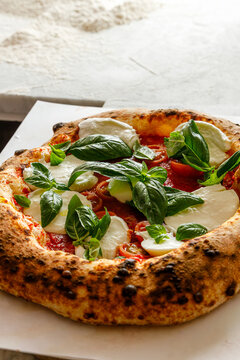 Craft pizza with mozzarella, basil and tomatoes isolated.
