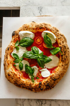 Craft pizza with mozzarella, basil and tomatoes isolated.