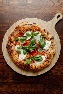 Craft pizza with mozzarella, basil and tomatoes isolated.