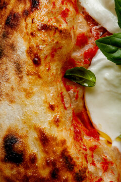 Texture of pizza with basil, mozzarella, tomatoes and ham close-up