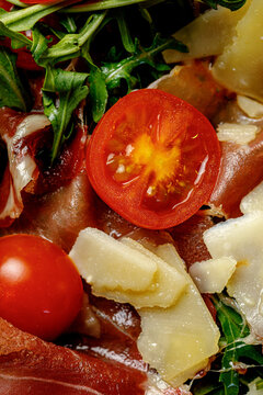 Texture of pizza with basil, mozzarella, tomatoes and ham close-up