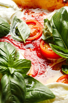 Texture of pizza with basil, mozzarella, tomatoes and ham close-up