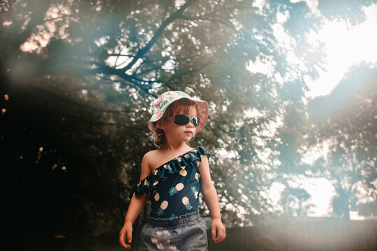 Young child wearing sunglasses outside on a sunny summer day