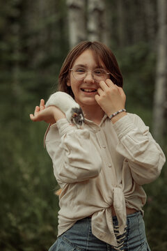 A portrait of a teenage girl wearing glasses with a cute domestic pet
