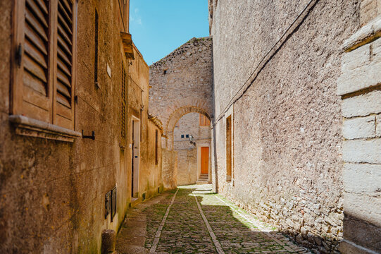 Narrow medieval alley with stone archway in Erice, Sicily, Italy