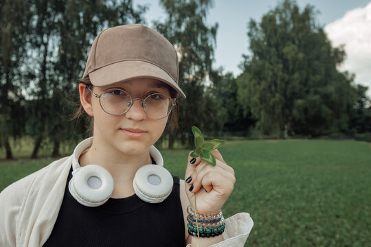 Closeup portrait of a teenage girl holding a lucky fourleaf clover in