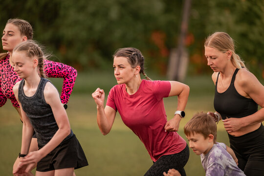 Women and children doing running drills in a park
