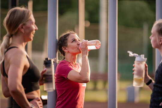 Women taking a water break during outdoor workout