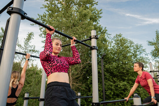 Young women training together on calisthenics bars
