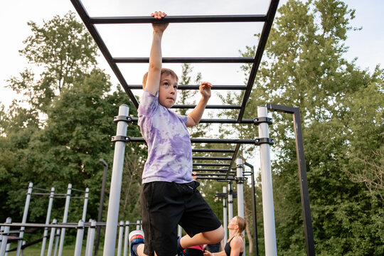 Young boy playing on outdoor monkey bars