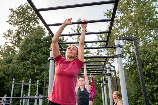 Woman using monkey bars at an outdoor gym