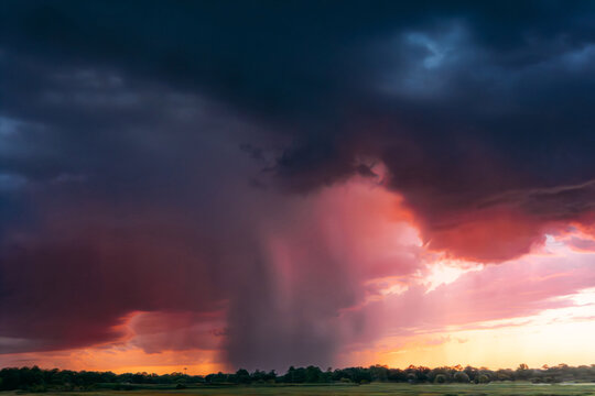 A dramatic rainstorm during a colorful sunset