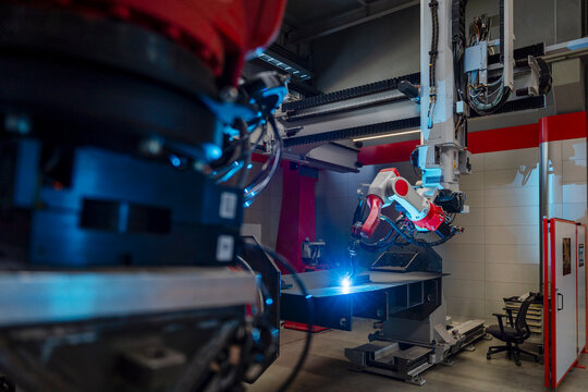 Automated industrial robot welding metal inside a modern factory