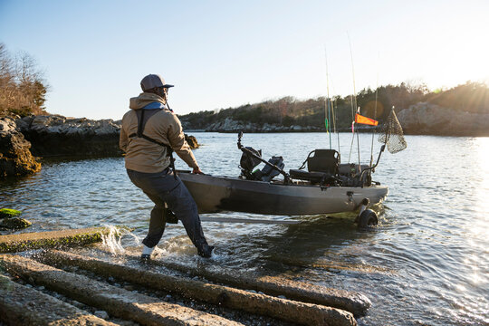 Fisherman launching his fishing kayak from ramp
