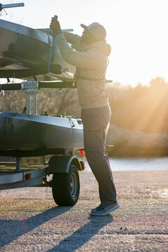 Man loading kayaks on trailer at sunrise