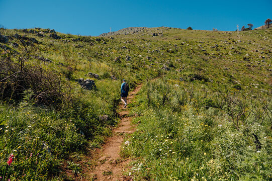 Hiker on mountain trail in Zingaro Nature Reserve, Sicily