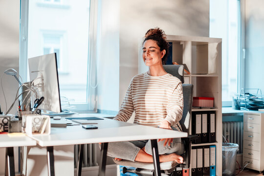 Businesswoman meditating at desk in office