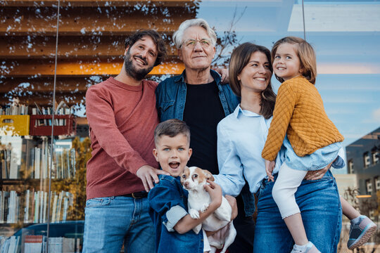 Happy family with dog in front of glass wall