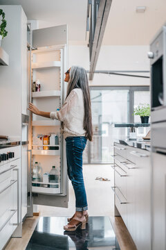 Woman in kitchen looking in fridge