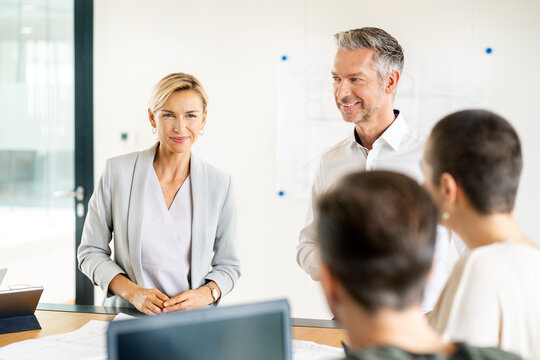 Senior businessman and woman leading workshop in office