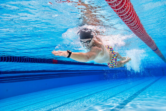 Athlete swimming freestyle underwater in a training pool