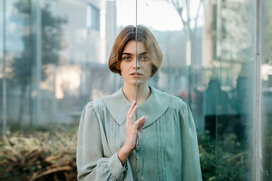 Portrait of woman with her face resting on a glass pane