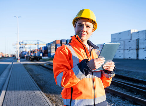 Logistics engineer with tablet at an outdoor freight terminal