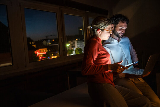 Team working late at night in office using notebook and tablet