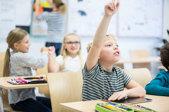 A young student actively participates in class using a tablet device to enhance his learning experience