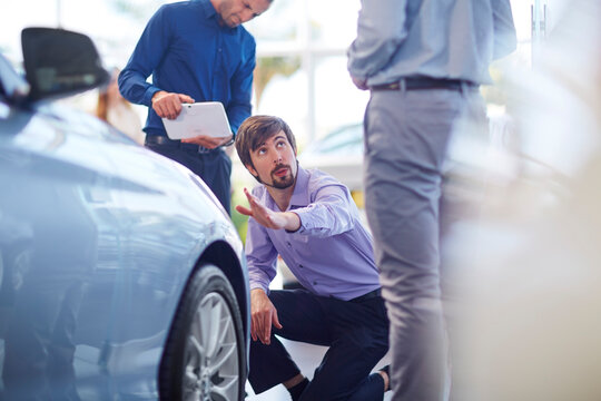 Car dealer talking to clients