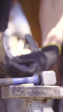 Farrier blacksmith hammer nails in to horseshoe close up