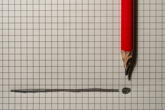 Red pencil with graphite line and dot on checkered paper. Sharp red pencil on grid paper next to drawn line and dot forming an exclamation mark concept for business planning, education or creativity