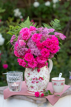 Blumenstrau&szlig; mit pink Zwergrosen "Roxy" und Sommerspiere-Bl&uuml;ten (Spiraea bumalda) im Sommergarten
