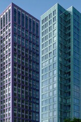 Fototapeta premium Two modern teal and purple office towers with glass facades for corporate background and poster design