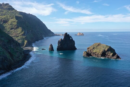 Aerial view of the iconic sea stacks rising from the Atlantic Ocean along the rugged coastline of Ribeira da Janela, Madeira, Portugal.