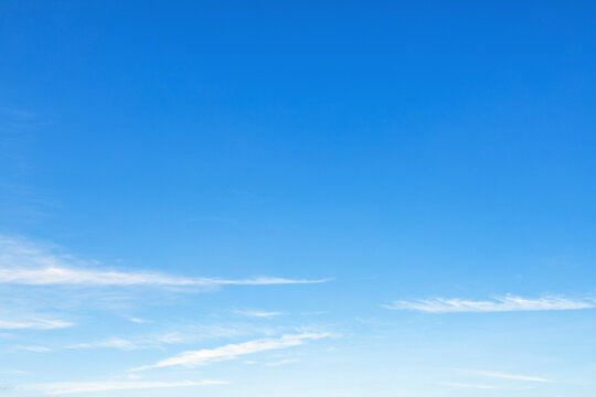 bright blue sky background with soft cloud trails texture