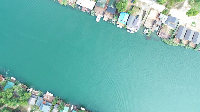 Cinematic aerial view of rustic wooden river houses and traditional fishing huts on Ada Bojana, Montenegro