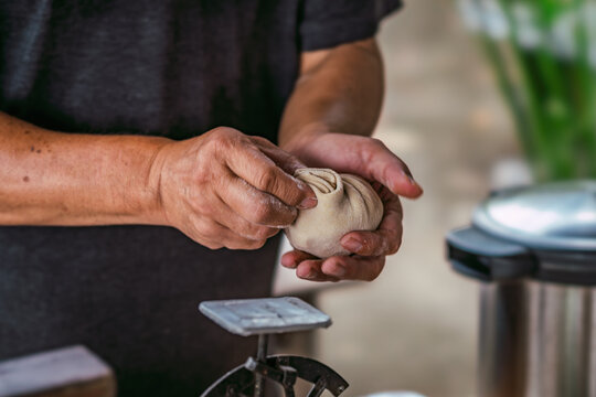 Chef skillfully pleating dough to make handmade dumplings. The intricate process of forming traditional Asian or Eastern European food like momos or khinkali.