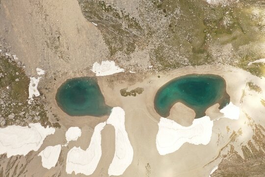 Aerial view of Lago di Pilato, two glacial lakes with turquoise water surrounded by rocky terrain and patches of snow in Montemonaco, Marche, Italy.