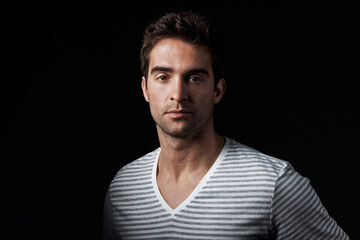Fototapeta premium Creative, man and designer in studio with portrait, career pride and about us for clothing launch. Serious, male person and entrepreneur with ambition, attitude and apparel tailor on dark background