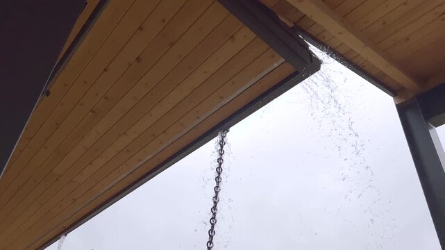 Close-up of rain falling from chain gutter system