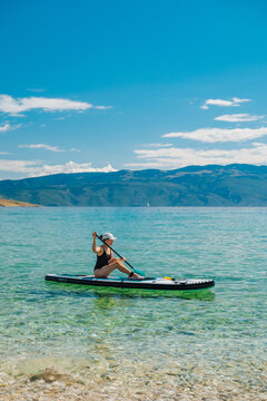 Woman paddleboarding on clear mountain lake