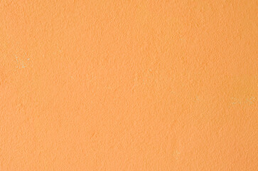 Fototapeta premium Bright orange colored plaster surface for energetic commercial backdrop designs.