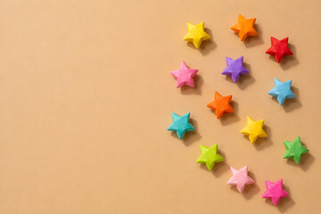 Colorful origami paper stars on a beige background with copy space