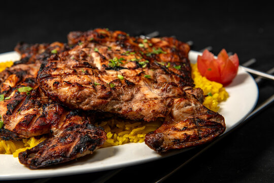Mix Grill Platter with chicken tikka, beef kabab, mutton kebab, seekh kabab and lamb chop with salad and fries served in dish isolated wooden table top view of tandoori grill bbq food
