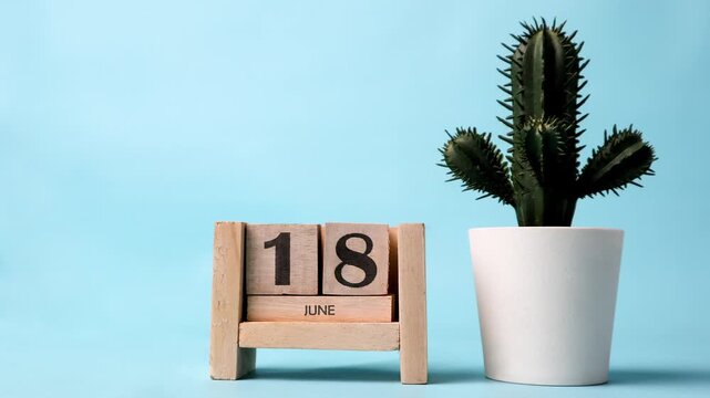 Month of June wooden block calendar timelapse with a plastic cactus on the side.