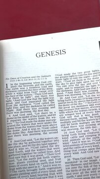 Opening to the Book of Genesis of the Old Testament in the Holy Bible. New Revised Standard Version. Vertical video.